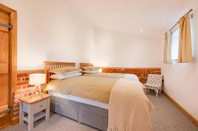 a bedroom with a large bed and a chair at 3 Bed in Kersey oc-tcbk in Kersey