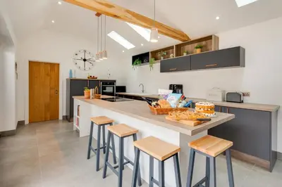 a kitchen with a large island with stools in it at 3 Bed in Kersey oc-tcbk in Kersey