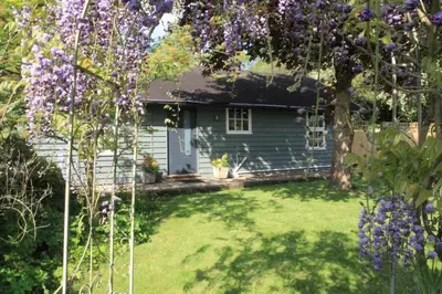 a garden with a house with purple flowers at 1 Bed in Debenham oc-glah in Worlingworth