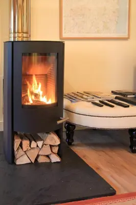 a fireplace in a living room with a mattress and a chair at 1 Bed in Debenham oc-glah in Worlingworth