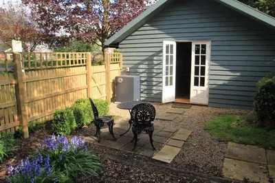 a patio with a table and chairs in front of a house at 1 Bed in Debenham oc-glah in Worlingworth