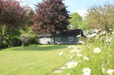 a house with a field of flowers in front of it at 1 Bed in Debenham oc-glah in Worlingworth
