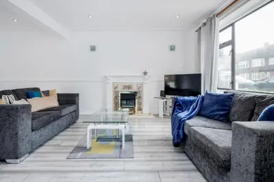 a living room with two couches and a tv at Bright and spacious home with free parking and garden in Mountnessing