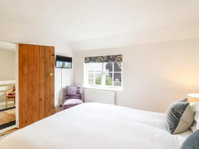 a bedroom with a bed and a window at Wherry Cottage in Manningtree