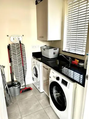 a kitchen with a washing machine and a washer at Fantastic Holiday Home in Laindon