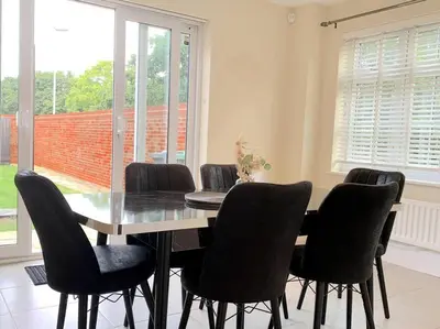 a dining room with a table and eight chairs at Fantastic Holiday Home in Laindon
