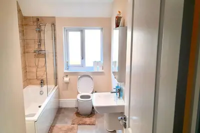 a bathroom with a toilet and a sink and a window at Fantastic Holiday Home in Laindon