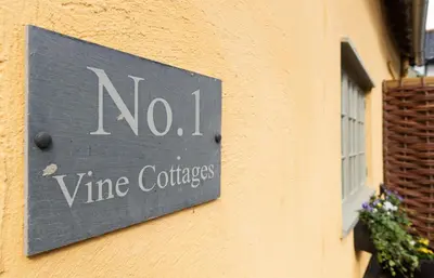a sign on a building that says no wine courses at Vine Cottage in Walsham le Willows