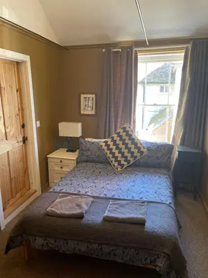 a bedroom with a bed and a window at Top House -Stylish property in village location in Bildeston