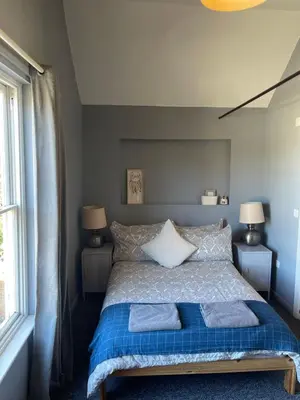 a bedroom with a bed with two towels on it at Top House -Stylish property in village location in Bildeston