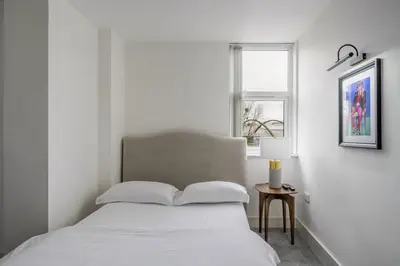 a white bedroom with a bed and a window at Luxurious 2 Bedroom Apartment with Free Parking, Sky TV, Sports, Movies & Netflix in Chelmsford