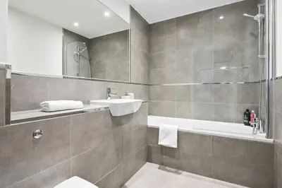 a bathroom with a sink and a toilet and a tub at Luxurious 2 Bedroom Apartment with Free Parking, Sky TV, Sports, Movies & Netflix in Chelmsford