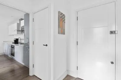 a white kitchen with white walls and white doors at Luxurious 2 Bedroom Apartment with Free Parking, Sky TV, Sports, Movies & Netflix in Chelmsford