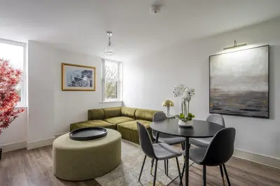 a living room with a couch and a table and chairs at Luxurious 2 Bedroom Apartment with Free Parking, Sky TV, Sports, Movies & Netflix in Chelmsford