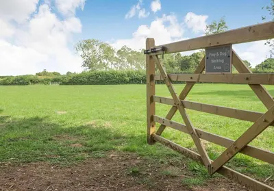 a wooden fence with a sign on it in a field at City to Country Retreat Luxury Lodges with Hot Tub, BBQ, Fire Pit in Toppesfield