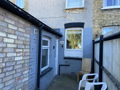 a building with a door and a window and two chairs at 160 Exning Road in Newmarket
