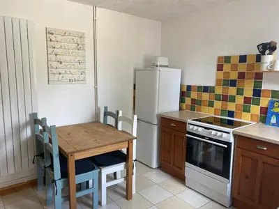 a kitchen with a table and a white refrigerator at 160 Exning Road in Newmarket