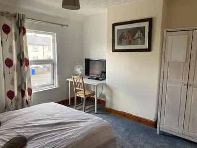 a bedroom with a bed and a desk with a television at 160 Exning Road in Newmarket