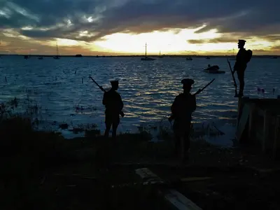 a group of three men standing in the water at sunset at Secluded Island Retreat - in the heart of the Anchorage in West Mersea