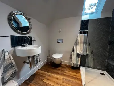 a bathroom with a sink and a toilet and a mirror at Secluded Island Retreat - in the heart of the Anchorage in West Mersea