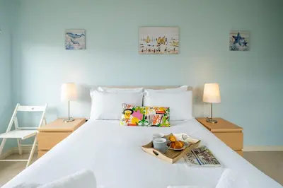 a white bed with a tray of food on it at 2 King Georges - Aldeburgh Coastal Cottages in Aldeburgh