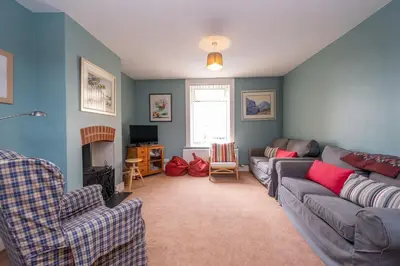 a living room with a couch and a fireplace at 40 Buller Road - Aldeburgh Coastal Cottages in Leiston