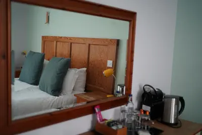 a mirror reflection of a bed in a room at The Old Cannon Brewery in Bury Saint Edmunds