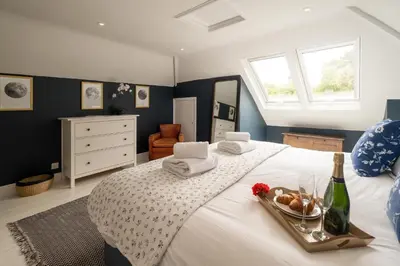 a bedroom with a white bed with a tray of food on it at Pinewood - Aldeburgh Coastal Cottages in Aldeburgh