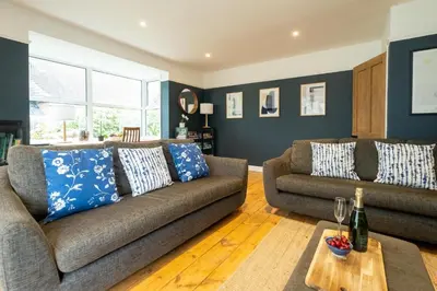 a living room with two couches and a table at Pinewood - Aldeburgh Coastal Cottages in Aldeburgh