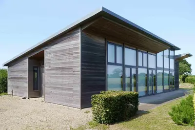 a small house with glass windows on a field at Upper Lodge, Shotley in Chelmondiston