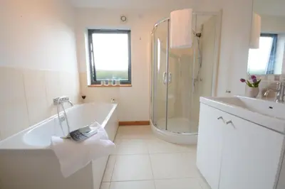 a bathroom with a tub and a shower and a sink at Upper Lodge, Shotley in Chelmondiston
