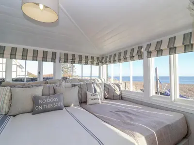 a room with a bed with a view of the beach at Valetta, Thorpeness in Thorpeness