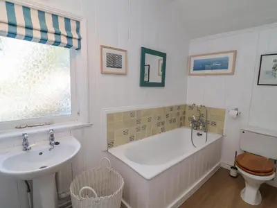 a bathroom with a tub and a sink and a toilet at Valetta, Thorpeness in Thorpeness