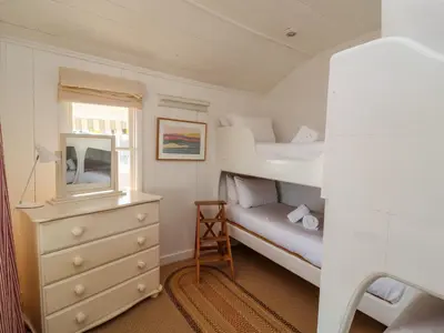 a small bedroom with two bunk beds and a dresser at Valetta, Thorpeness in Thorpeness