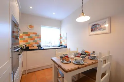 a kitchen with a wooden table with plates of food on it at The Hideaway, Aldeburgh in Aldeburgh