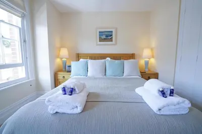 a bedroom with a large bed with towels on it at The Hideaway, Aldeburgh in Aldeburgh