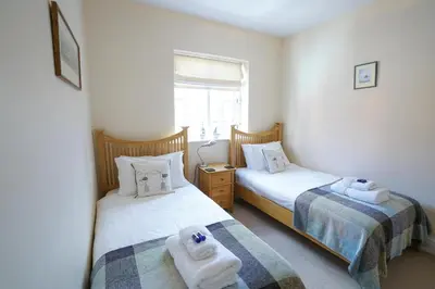 two beds in a room with towels on them at The Hideaway, Aldeburgh in Aldeburgh