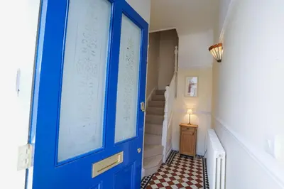 a blue door in a hallway with a staircase at The Hideaway, Aldeburgh in Aldeburgh