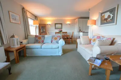 a living room with two white couches and a table at Crabbe House in Aldeburgh