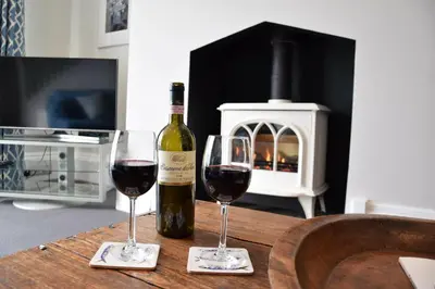 two glasses of wine sitting on a table with a bottle of wine at Regatta Lookout in Aldeburgh