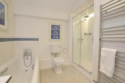 a white bathroom with a shower and a toilet at Regatta Lookout in Aldeburgh