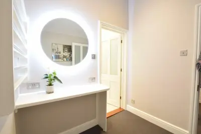 a dressing room with a mirror and a sink at Regatta Lookout in Aldeburgh
