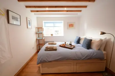 a bedroom with a large bed with a tray on it at Vesta Cottage, Orford in Orford