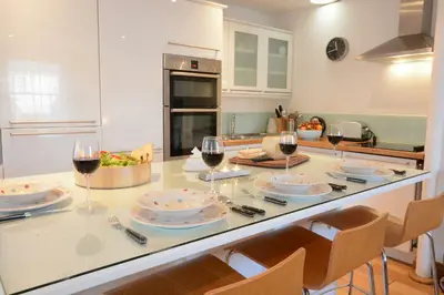a kitchen with a table with glasses of wine at Vesta Cottage, Orford in Orford