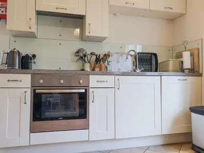 a kitchen with white cabinets and an oven at Romulus in Roudham