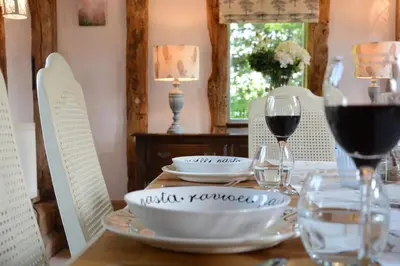 a table with glasses of wine and a plate of food at Wassicks Cottage, Haughley in Haughley