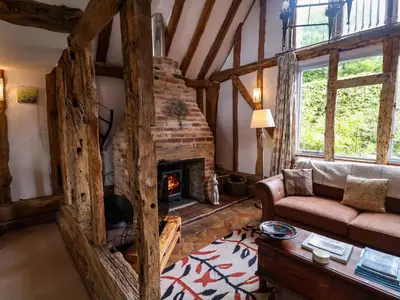 a living room with a couch and a fireplace at Wassicks Cottage, Haughley in Haughley