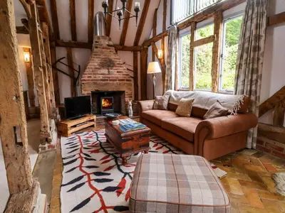 a living room with a couch and a fireplace at Wassicks Cottage, Haughley in Haughley