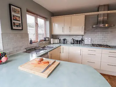 a kitchen with a wooden cutting board on a counter at Holly Lodge in Aldeburgh