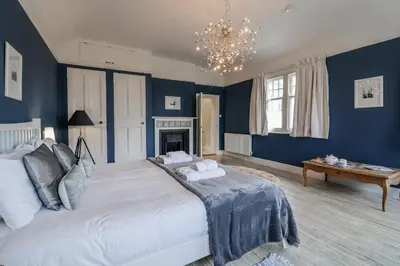 a bedroom with blue walls and a large bed at Holly Lodge in Aldeburgh
